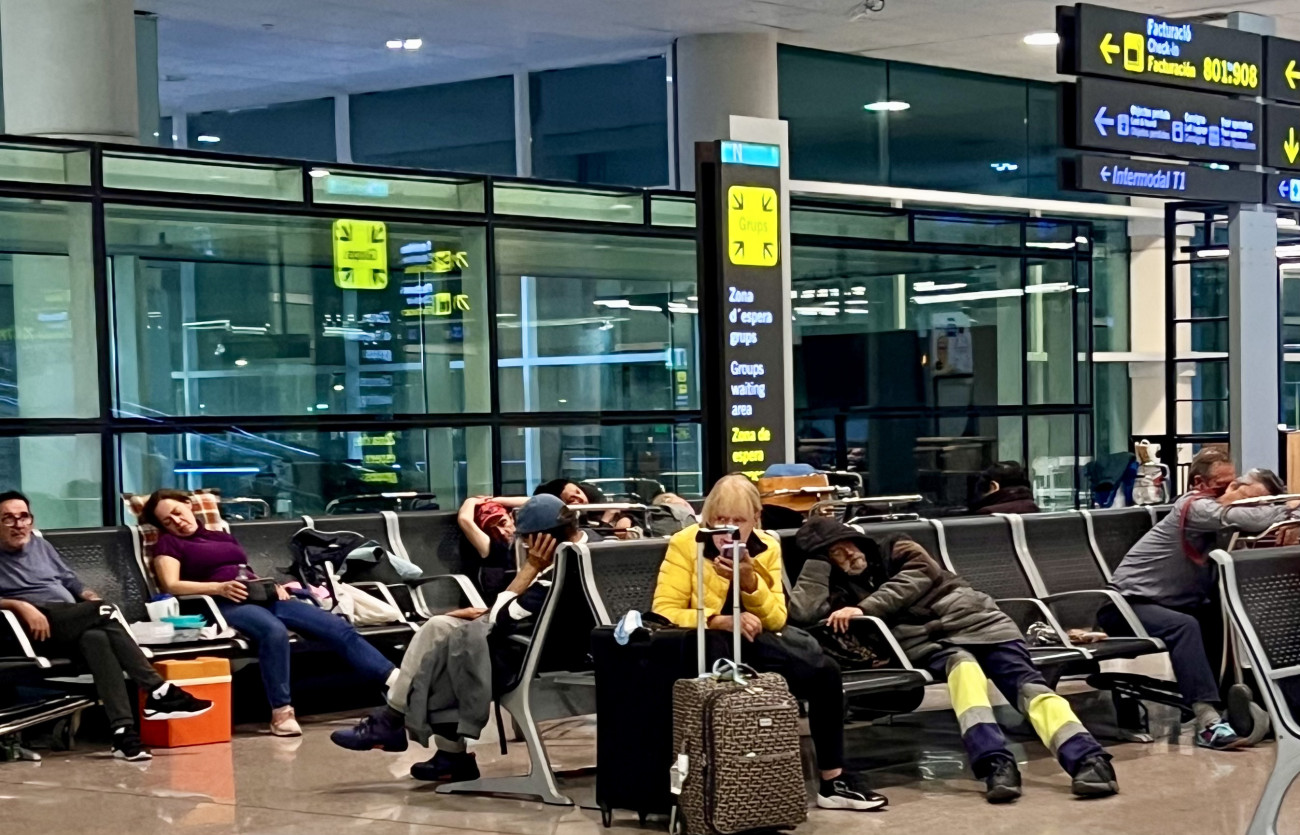 Passatgers i persones sense llar dormint a l´arribada de la Terminal 2 de l’aeroport d’El Prat