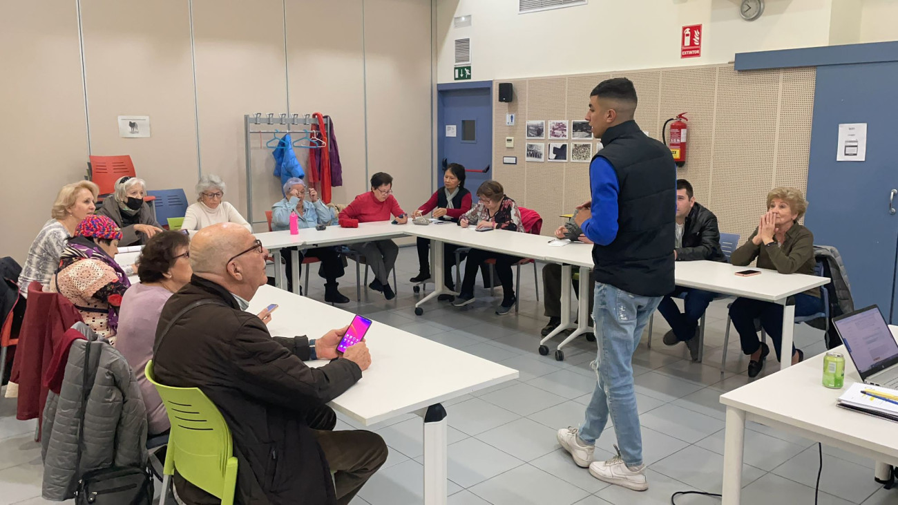 Moad en una classe pràctica per ajudar a utilitzar el mòbil