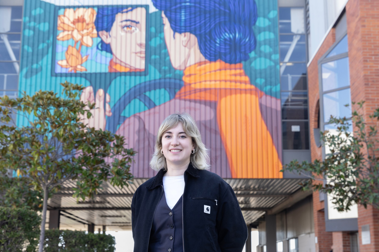 La artista Lidia Cao, autora del gran mural en la planta de SEAT, delante de su obra