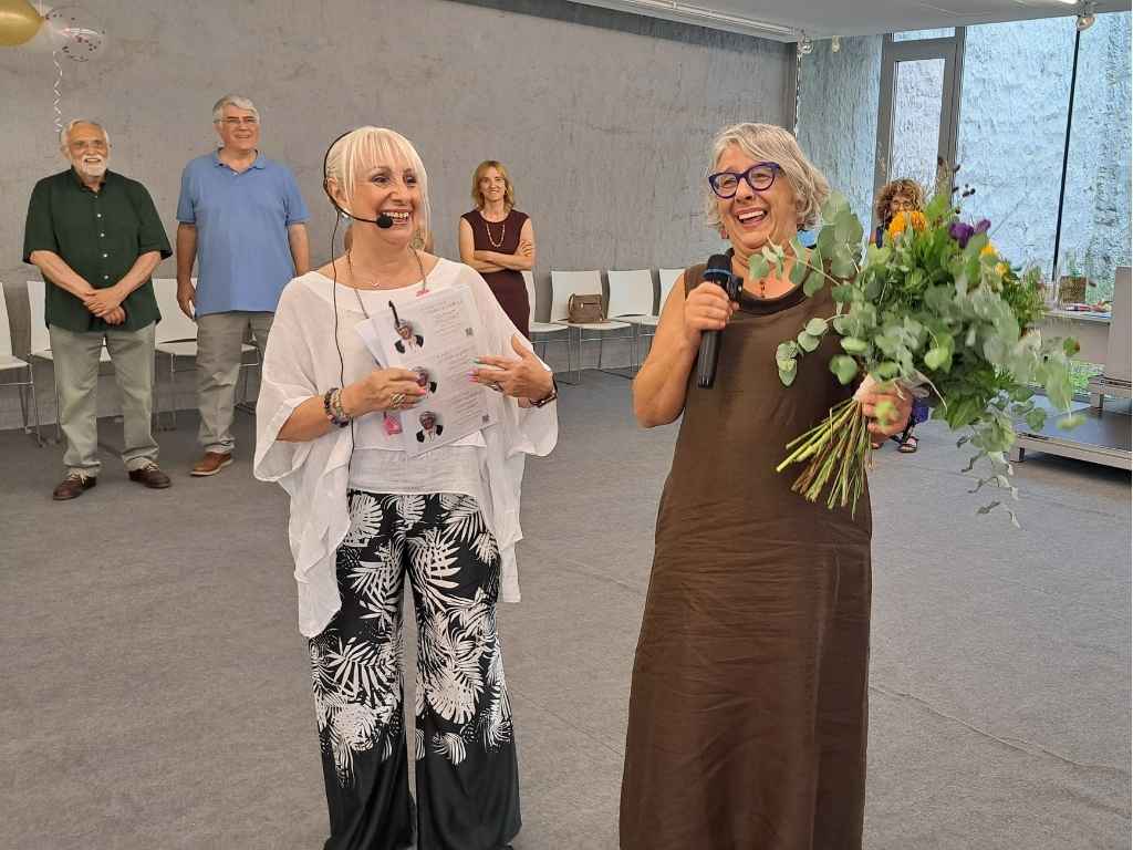 El CECBLL ha organitzat una festa de comiat laboral d’Esther Hachuel. A la imatge, rep un ram de flors de Conxita Sánchez Medina, expresidenta del centre