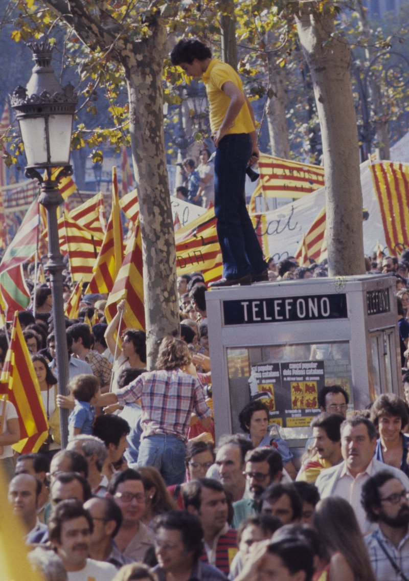 Instantània de la plaça de Catalunya de Sant Boi el 1976 que simbolitza que, quan no hi havia telèfons mòbils i, per tant, no teníem aquesta falsa sensació actual d’hipercomunicació, era més fàcil el diàleg