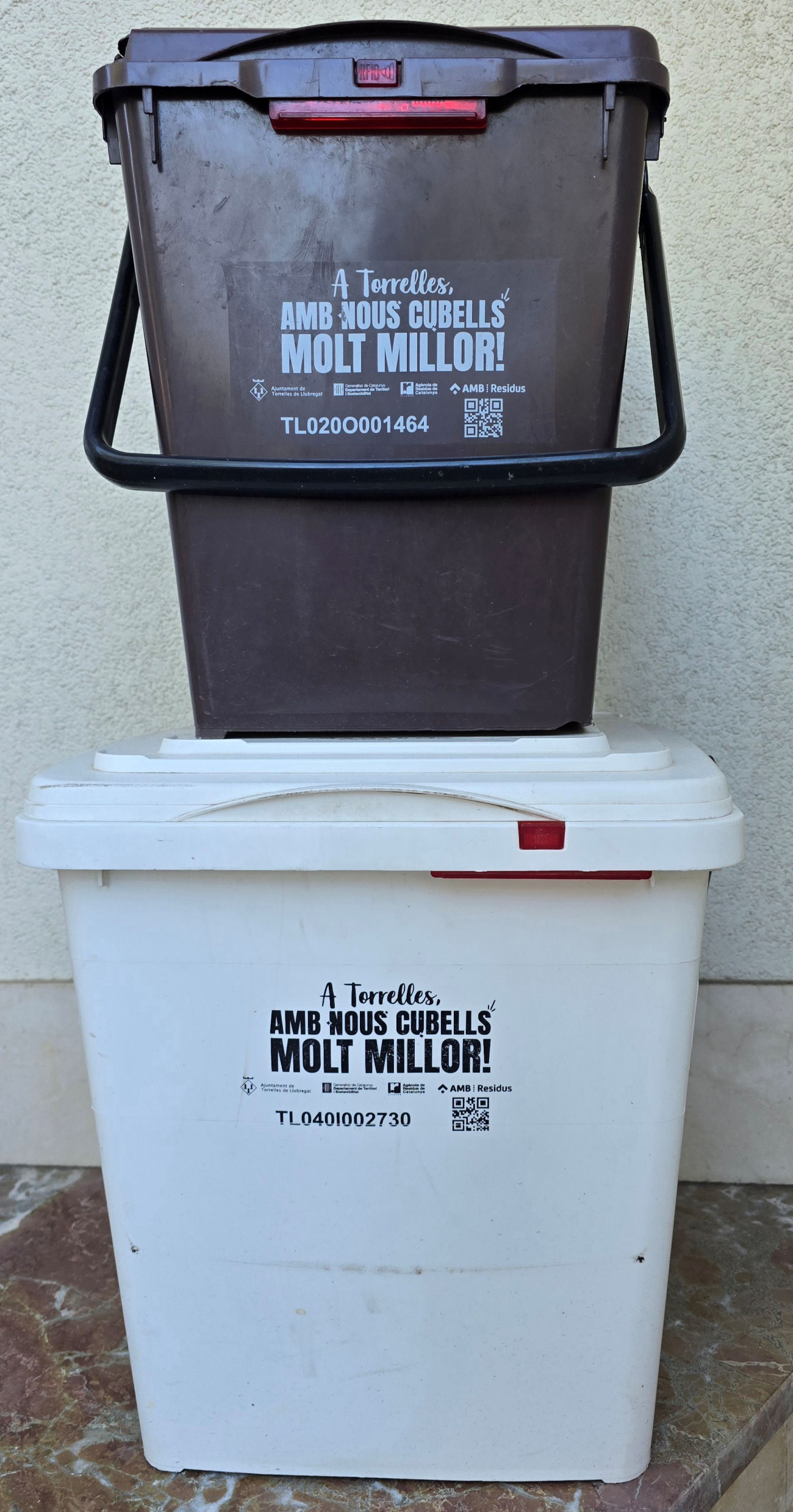 Estos son los cubos que se utilizan en Torrelles. El de color marrón es para la fracción inorgánica y el blanco, hasta ahora solo para el resto, se utilizará según los días para la fracción resto y para los envases